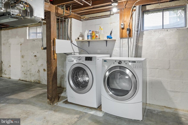 clothes washing area featuring washer and dryer and a healthy amount of sunlight