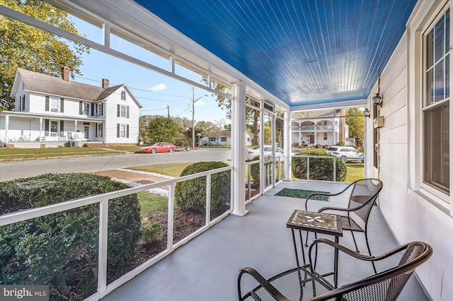 sunroom / solarium featuring a healthy amount of sunlight and a residential view