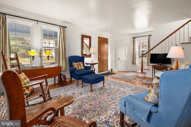 living room with a wealth of natural light, wood finished floors, baseboards, and stairs