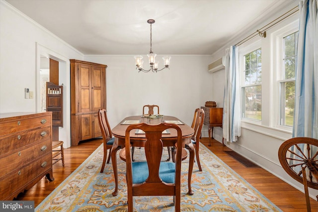 dining area with crown molding, a wall mounted AC, a notable chandelier, and light hardwood / wood-style floors