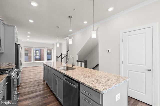 kitchen featuring hanging light fixtures, an island with sink, sink, gray cabinets, and stainless steel appliances