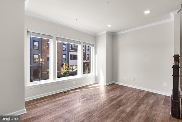 spare room with hardwood / wood-style floors and crown molding