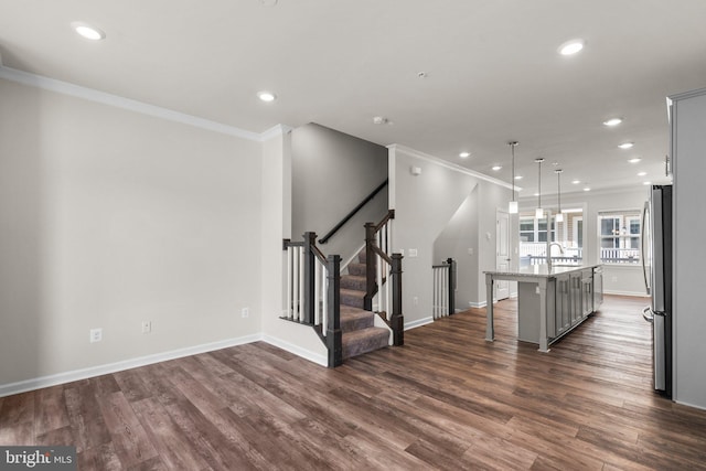 interior space featuring dark hardwood / wood-style flooring, a breakfast bar, a kitchen island with sink, stainless steel refrigerator, and gray cabinetry