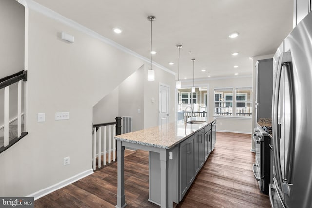 kitchen with an island with sink, hanging light fixtures, gray cabinetry, stainless steel appliances, and dark hardwood / wood-style flooring