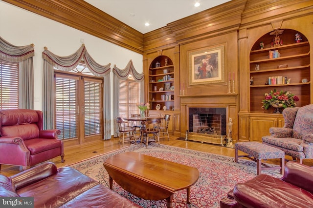 living room featuring crown molding, built in features, and wood-type flooring