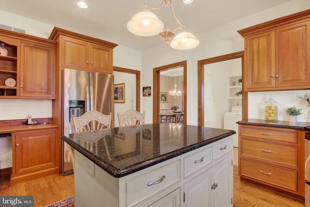 kitchen with a kitchen island, light hardwood / wood-style flooring, stainless steel fridge, an inviting chandelier, and white cabinets