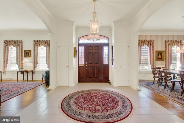 foyer with light hardwood / wood-style floors, ornamental molding, and plenty of natural light