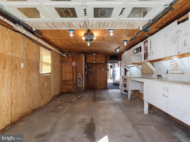 interior space featuring wooden walls and concrete floors