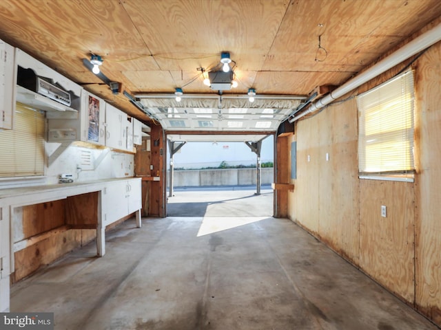 garage featuring wood ceiling and wooden walls