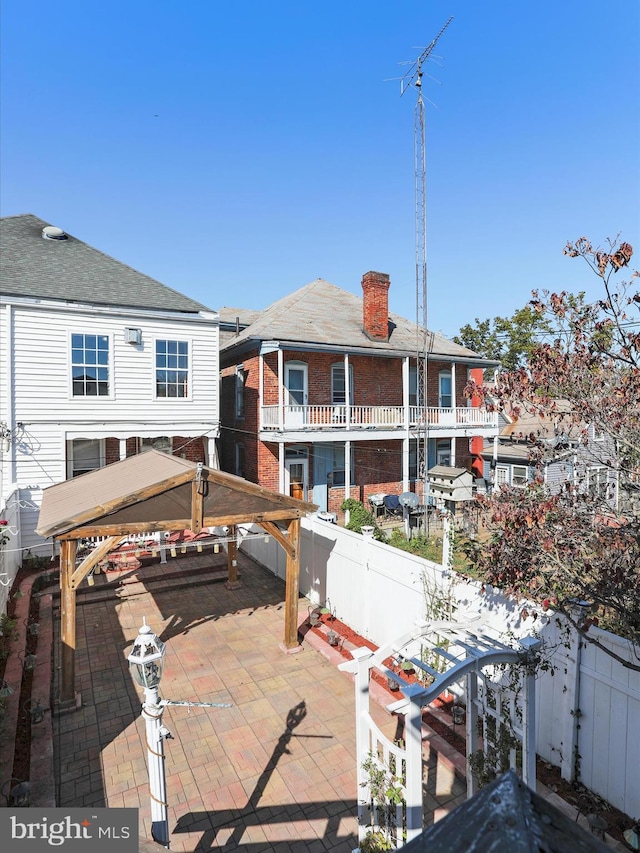 rear view of house featuring a patio and a gazebo