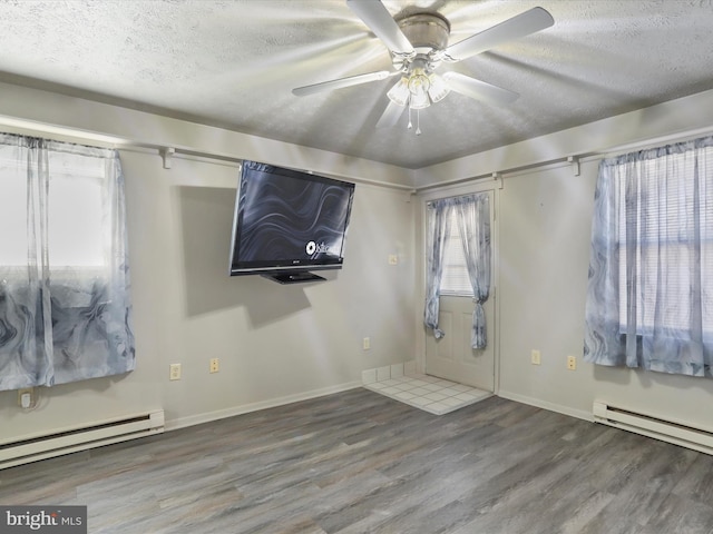 foyer featuring a textured ceiling, baseboard heating, wood-type flooring, and ceiling fan