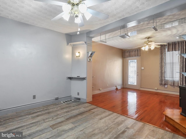 interior space featuring a textured ceiling, wood-type flooring, and ceiling fan