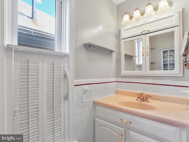 bathroom featuring vanity and tile walls