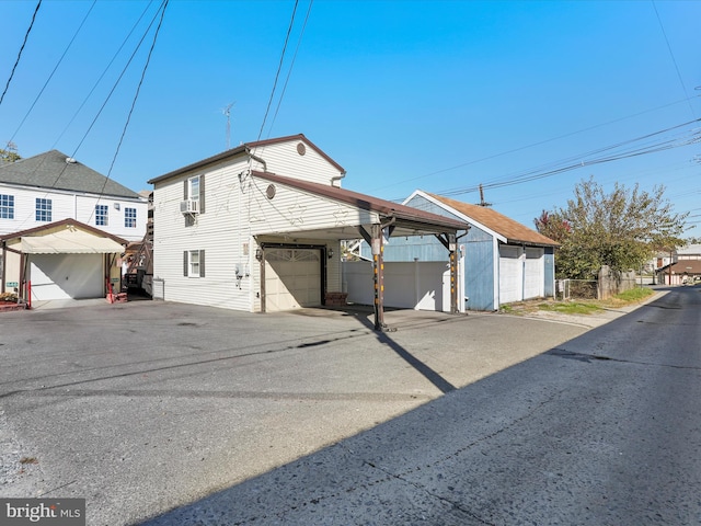 exterior space featuring a garage, cooling unit, and a carport