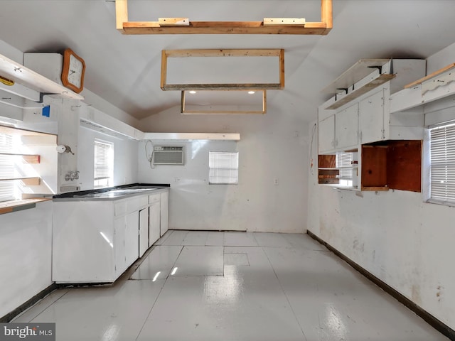 kitchen featuring vaulted ceiling, a wall mounted air conditioner, and white cabinets