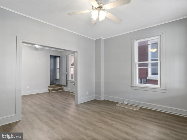 unfurnished room with ornamental molding, hardwood / wood-style floors, and ceiling fan