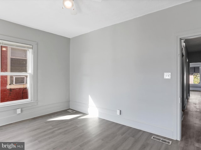 unfurnished room with cooling unit, hardwood / wood-style floors, and ceiling fan