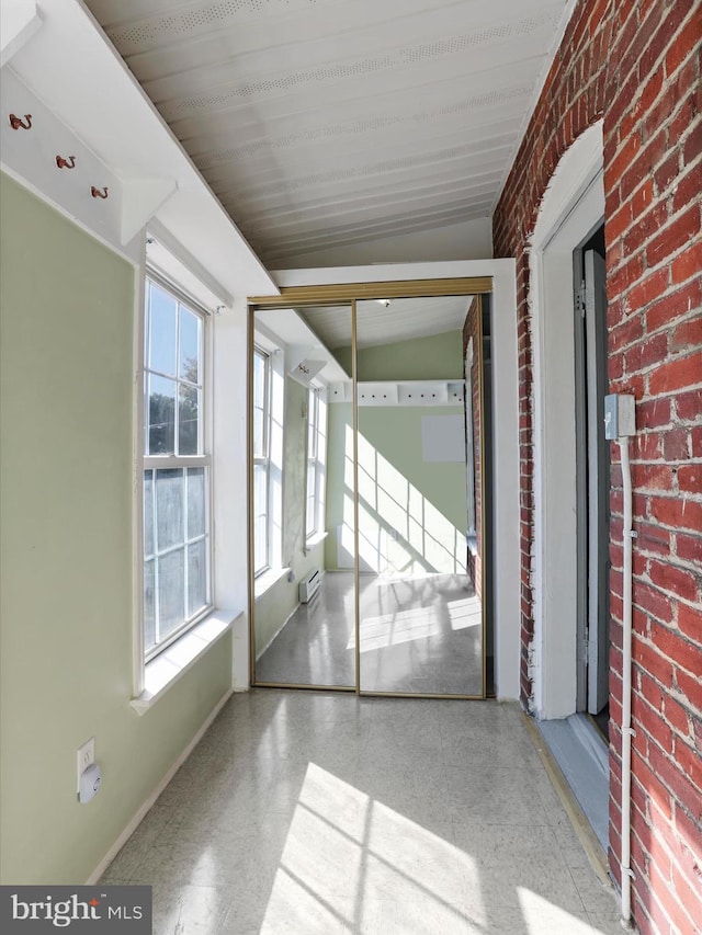 interior space featuring brick wall and vaulted ceiling