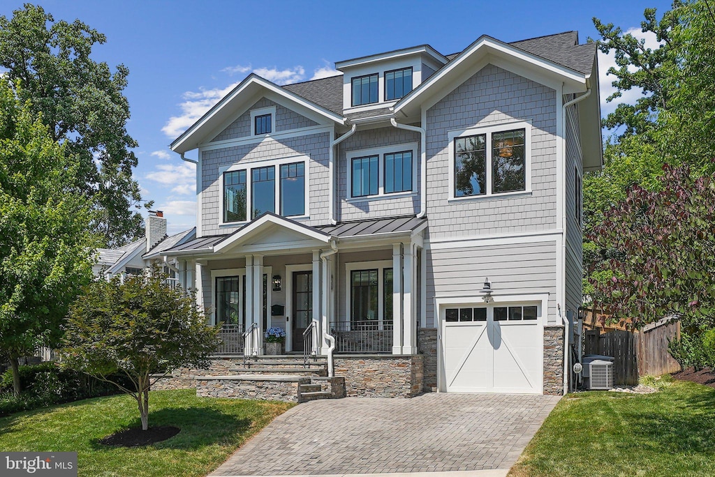 craftsman inspired home featuring central AC, a front yard, a garage, and a porch