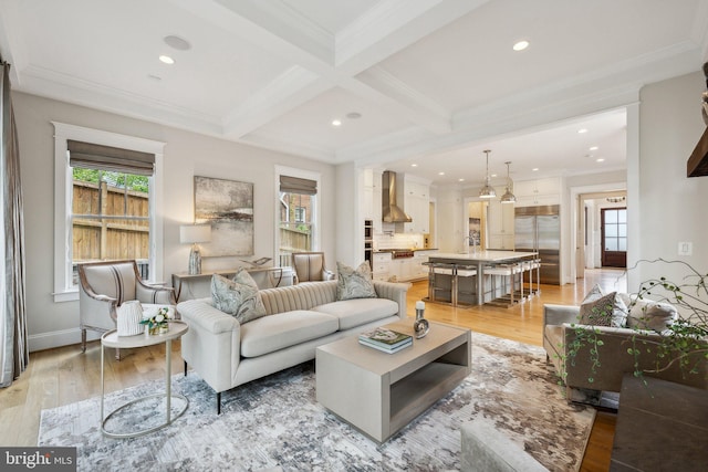 living room with crown molding, beam ceiling, coffered ceiling, and light wood-type flooring