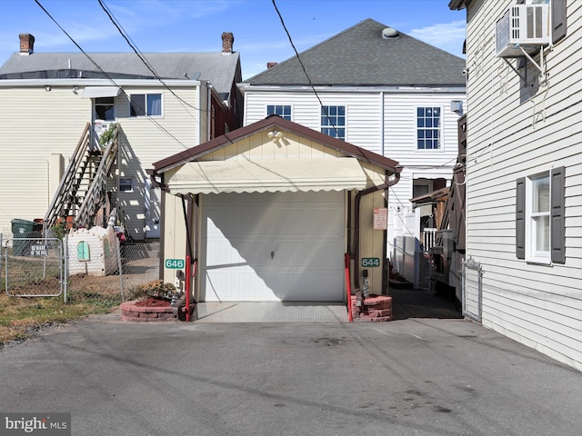 rear view of property featuring a garage and cooling unit