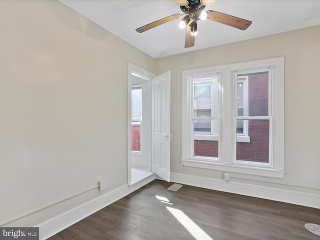 spare room with dark hardwood / wood-style floors and ceiling fan