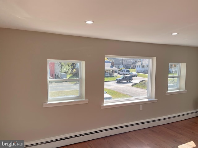 empty room featuring a baseboard radiator and hardwood / wood-style flooring