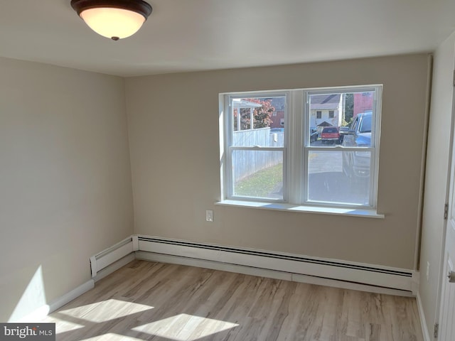 unfurnished room with light hardwood / wood-style flooring and a baseboard heating unit