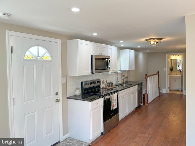 kitchen featuring appliances with stainless steel finishes, white cabinets, and dark hardwood / wood-style flooring