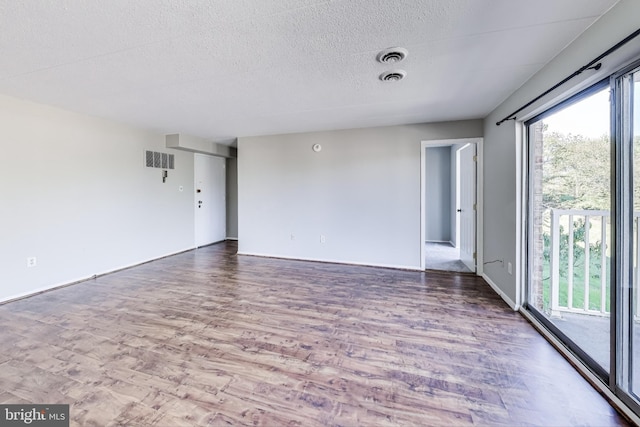 unfurnished room with a textured ceiling and hardwood / wood-style flooring