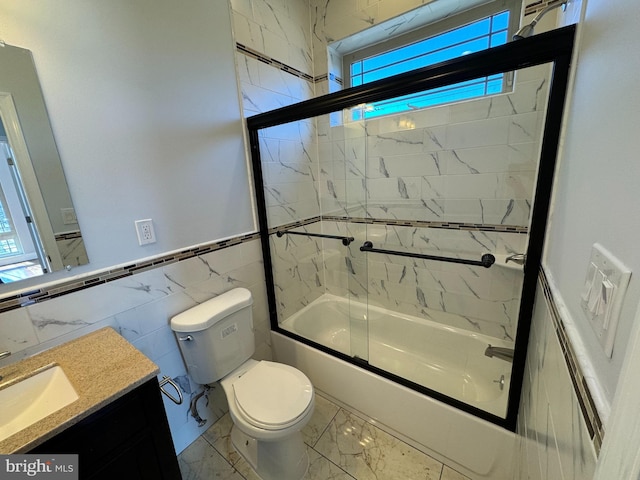 full bathroom with toilet, combined bath / shower with glass door, vanity, and tile walls