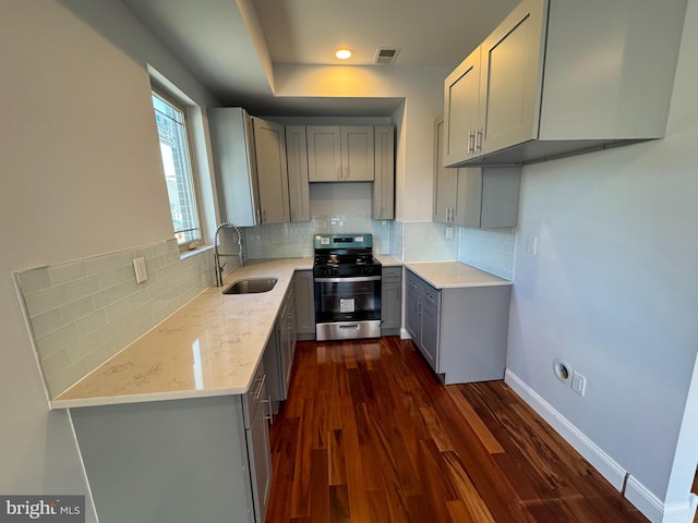 kitchen with gray cabinetry, sink, dark hardwood / wood-style floors, and stainless steel stove