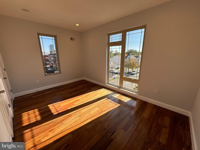 spare room with dark hardwood / wood-style flooring