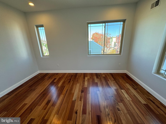 unfurnished room with dark wood-type flooring