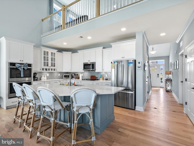 30579 Canary Way Unit 5, Ocean View, DE 19970 - kitchen with appliances with stainless steel finishes, backsplash, light countertops, white cabinets, and a towering ceiling
