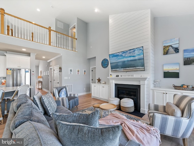 living room with high vaulted ceiling and light hardwood / wood-style flooring