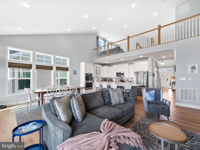 living room featuring hardwood / wood-style flooring and high vaulted ceiling