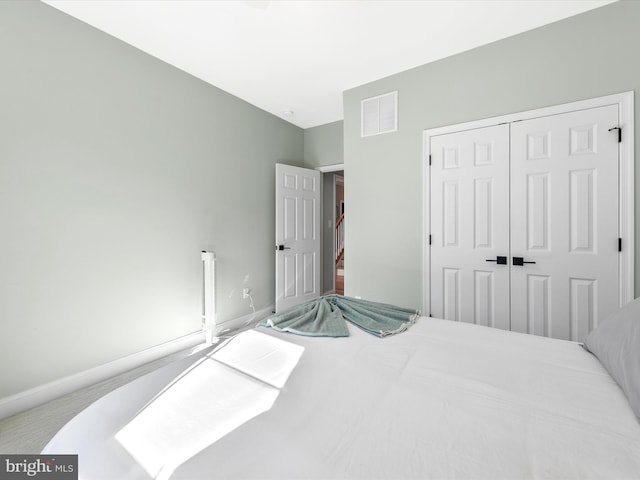 bedroom with light colored carpet and a closet