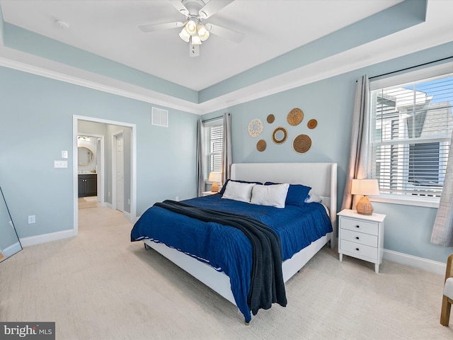 carpeted bedroom featuring multiple windows, a raised ceiling, and ceiling fan