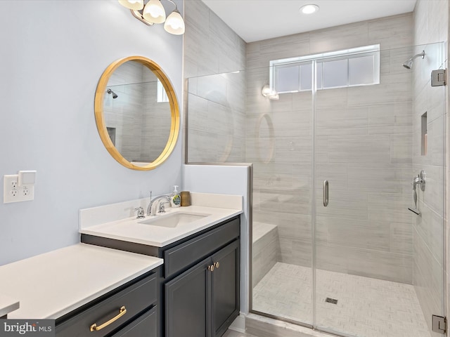 bathroom featuring vanity, a shower with shower door, and wood-type flooring