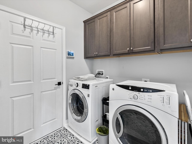 clothes washing area with cabinets and washing machine and clothes dryer