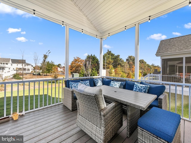 wooden terrace with a sunroom and a lawn