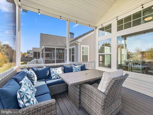 deck featuring an outdoor living space and a sunroom