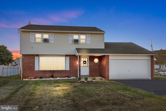 view of property featuring a lawn, cooling unit, and a garage