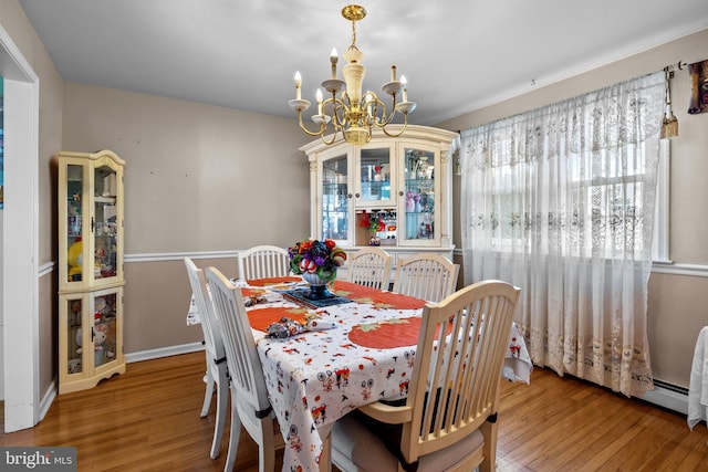 dining area featuring a chandelier and wood-type flooring