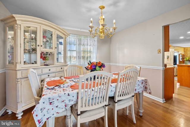 dining space featuring an inviting chandelier and light wood-type flooring