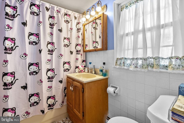 full bathroom featuring vanity, toilet, tile walls, and shower / tub combo