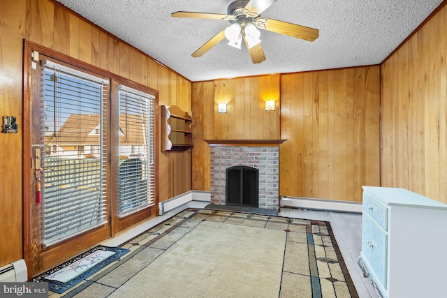 unfurnished living room with a fireplace, a textured ceiling, wooden walls, and a baseboard radiator