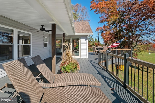 wooden deck with ceiling fan and a yard