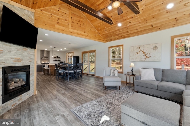 living room featuring a stone fireplace, hardwood / wood-style flooring, wooden ceiling, high vaulted ceiling, and beamed ceiling